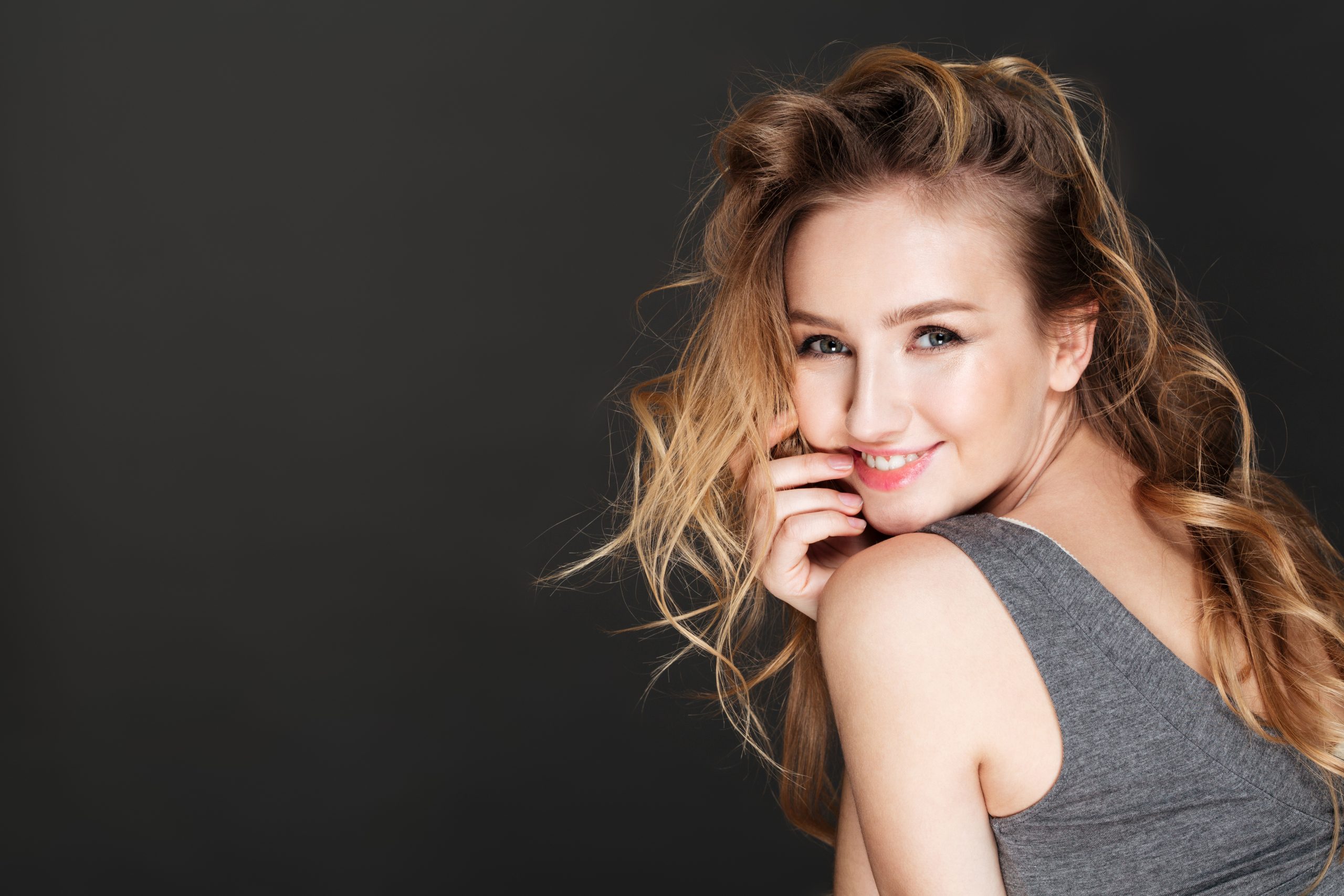 Young gorgeous woman posing over dark background