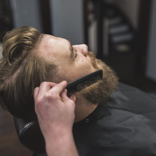 estilista-sin-rostro-combinandose-la-barba-del-hombre